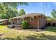 The side of a brick home with tidy landscaping and a well-maintained lawn at 464 Camp Rd, Burlington, NC 27217