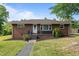 Charming brick home featuring a well-manicured lawn and inviting front entry at 464 Camp Rd, Burlington, NC 27217