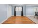 Well-lit living room with hardwood floors, ceiling fan, and view into the kitchen at 464 Camp Rd, Burlington, NC 27217