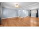 Hardwood floored living room with white trim, ceiling fan, and neutral light-blue walls at 464 Camp Rd, Burlington, NC 27217