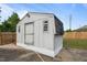 Exterior view of a white storage shed with a shingled roof, set on a concrete slab in the backyard at 464 Camp Rd, Burlington, NC 27217