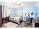 A bright blue bedroom offers ample natural light, complete with a cozy bed, desk, and functional storage options at 509 Stokes Rd, Graham, NC 27253