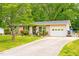 A single-story home with a long driveway, lawn, and landscaped flower beds at 509 Stokes Rd, Graham, NC 27253