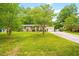 Well-maintained single-story home with lush front lawn and a long driveway to the attached garage at 509 Stokes Rd, Graham, NC 27253