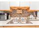 A stainless steel kitchen sink with double basins and a modern faucet, complemented by backsplash and ample countertop space at 509 Stokes Rd, Graham, NC 27253