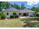 Spacious backyard with manicured lawn, lush shrubs, patio and covered porch offers a tranquil outdoor retreat at 512 Page St, Cary, NC 27511