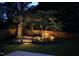 Night view of the backyard patio highlighting landscape lighting, stone pathway, and seating area at 512 Page St, Cary, NC 27511