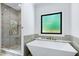 Bathroom featuring a soaking tub, modern shower and light grey tile accents at 512 Page St, Cary, NC 27511
