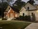 Stunning night view of a white home showcasing a wood-accented porch and well-lit landscaping at 512 Page St, Cary, NC 27511