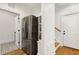Hallway with stainless steel refrigerator, wooden floors, and patterned tile entryway at 512 Page St, Cary, NC 27511