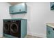 Laundry room features a washer and dryer with light blue cabinets and patterned floors at 512 Page St, Cary, NC 27511