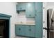 Laundry room features a sink with light blue cabinets, stainless refrigerator and patterned floors at 512 Page St, Cary, NC 27511