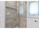 Tiled walk-in shower with glass door, bench seating and a decorative tile shelf offers a luxurious spa experience at 512 Page St, Cary, NC 27511