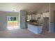 Open-concept kitchen with white cabinets, island, and sliding glass doors to the backyard at 519 Mulberry Rd, Spring Hope, NC 27882