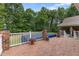 Brick patio showcasing a partially covered pool, complemented by lush greenery and a white railing at 5237 Christian Light Rd, Fuquay Varina, NC 27526