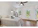 Bedroom with hardwood floors, white walls and trim, ceiling fan, and natural light through multiple windows at 5237 Christian Light Rd, Fuquay Varina, NC 27526