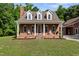 Charming brick house features white columns, rocking chairs, and mature landscaping at 5237 Christian Light Rd, Fuquay Varina, NC 27526