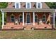 A brick front porch with stately columns, rocking chairs, and fresh landscaping at 5237 Christian Light Rd, Fuquay Varina, NC 27526