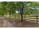 Picturesque pasture bordered by a wooden fence and mature trees along a gravel path at 5237 Christian Light Rd, Fuquay Varina, NC 27526