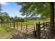 Fenced pasture with metal gates and lush green grass and mature trees at 5237 Christian Light Rd, Fuquay Varina, NC 27526