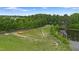 Scenic pasture with lush green grass, white fencing, mature trees, and a serene pond in the background at 5237 Christian Light Rd, Fuquay Varina, NC 27526