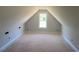View of unfinished attic space featuring light walls, wood flooring and a bright window at 529 Mulberry Rd, Spring Hope, NC 27882