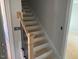 Bright, unfinished staircase featuring light wood handrail and black metal balusters to upper level at 529 Mulberry Rd, Spring Hope, NC 27882