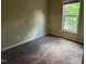 A bright, empty bedroom with neutral walls, carpeting, a window, and white trim at 532 Matheson Pl, Cary, NC 27511