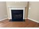 Cozy fireplace with a white mantel and black surround, set in a corner at 532 Matheson Pl, Cary, NC 27511