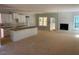 Open-concept living space with fireplace, white kitchen cabinets, and unfinished floors at 539 Mulberry Rd, Spring Hope, NC 27882