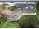 Aerial view of backyard featuring a stone patio, seating area, lush greenery, and manicured lawn perfect for outdoor living at 6 Beltre Ct, Durham, NC 27705