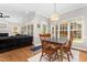 Bright dining area features hardwood floors, an elegant light fixture, and large windows overlooking the backyard at 6 Beltre Ct, Durham, NC 27705