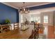Spacious dining room with rustic wooden table, pendant lighting, dark blue accent wall, and hardwood flooring at 6 Beltre Ct, Durham, NC 27705