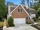 Brick two-story home showcasing a two-car garage and mature landscaping in the front yard at 6 Beltre Ct, Durham, NC 27705