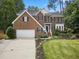 Charming two-story brick home with a well-manicured lawn, mature trees, and a driveway at 6 Beltre Ct, Durham, NC 27705