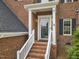 Inviting front door entrance with brick steps, white columns, and a glass storm door at 6 Beltre Ct, Durham, NC 27705