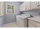 Convenient laundry room with a washer, dryer, overhead cabinets, and a window for natural light at 6 Beltre Ct, Durham, NC 27705