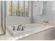 Bright bathroom with a soaking tub under a window, featuring updated fixtures and a clean, modern design at 6 Beltre Ct, Durham, NC 27705