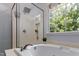 Modern bathroom showcasing a luxurious soaking tub, separate shower, and natural light creating a spa-like experience at 6 Beltre Ct, Durham, NC 27705