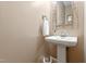 Clean powder room with a pedestal sink, decorative mirror, and neutral wall color at 6 Beltre Ct, Durham, NC 27705