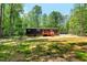 A spacious backyard, featuring the home, a deck, and a lush forest backdrop at 6082 Zachary Lane Ln # 1S, Oxford, NC 27565
