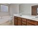 Bathroom with double vanity, soaking tub, and a large mirror at 752 Wickham Ridge Rd, Apex, NC 27539