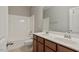 Bathroom features double sinks, brown cabinets, and shower/tub combo at 752 Wickham Ridge Rd, Apex, NC 27539
