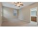Neutral bedroom adjacent to bathroom featuring carpet and ceiling fan at 752 Wickham Ridge Rd, Apex, NC 27539
