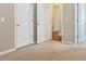 Neutral bedroom features two white doors, beige carpet, and neutral paint at 752 Wickham Ridge Rd, Apex, NC 27539