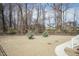 Spacious backyard with young trees, patio, and view of light gray and blue home at 76 Freewill Pl, Raleigh, NC 27603