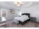Spacious main bedroom boasts tray ceilings, modern decor, and two bright windows with scenic views at 76 Freewill Pl, Raleigh, NC 27603