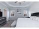 Bright bedroom with white paneled accent wall, tray ceiling, ceiling fan, and two large windows at 76 Freewill Pl, Raleigh, NC 27603