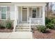 Charming front porch with stone steps, a cozy sitting area, and meticulously maintained landscaping at 76 Freewill Pl, Raleigh, NC 27603