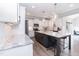 Bright kitchen showcases white cabinets, stainless appliances, gray island with seating, and wood-look floors at 76 Freewill Pl, Raleigh, NC 27603